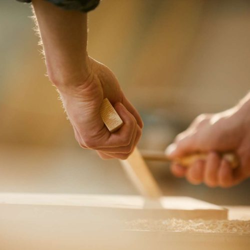 Close,Up,Of,Unrecognizable,Carpenter,Carving,Wood,While,Working,In