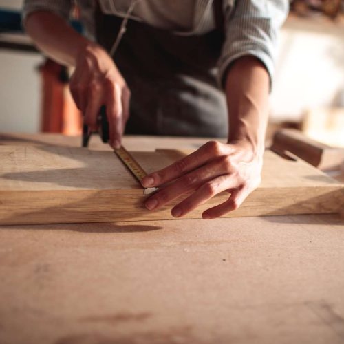 Close,Up,Of,A,Young,Carpenter,Measuring,A,Wood,Plank