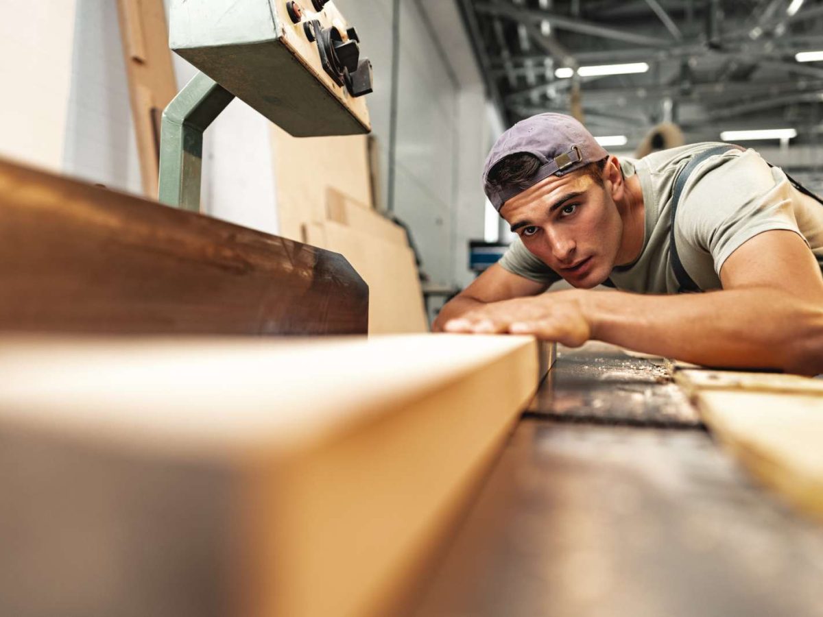 Young,Carpenter,Working,On,Woodworking,Machines,In,The,Furniture,Factory