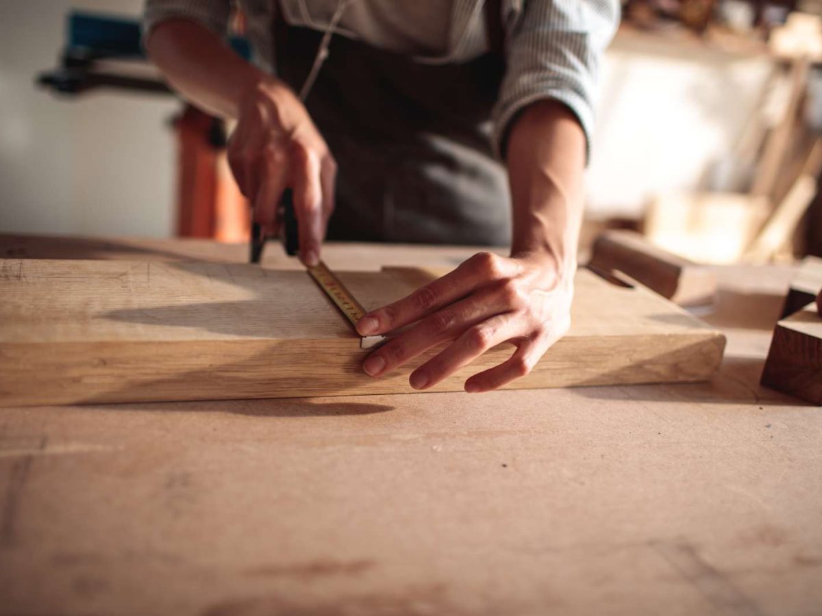 Close,Up,Of,A,Young,Carpenter,Measuring,A,Wood,Plank